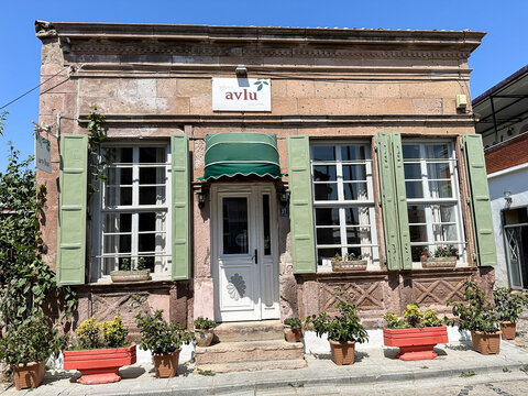 Cunda, Turkey - 22.08.2023. Colorful cafes and restaurants along the streets of Cunda island, Balikesir. Street view in Cunda in Ayvalik is an old town by the Aegean Sea. Avlu restaurant facade