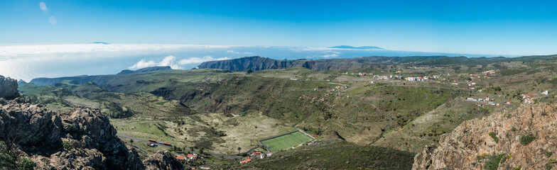 Fototapeta premium Panoramic view from peak of Alto de at Garajonay mountain with l forest and hills, Garajonay National Park, La Palma island and small villages. La Gomera, Canary Islands, Spain.