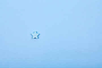 One alone blue wooden star shape symbol label form isolated on the bright solid fond plain bright blue background
