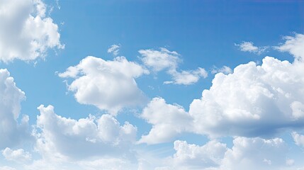Naklejka na ściany i meble An image of a clear blue sky adorned with fluffy white clouds.