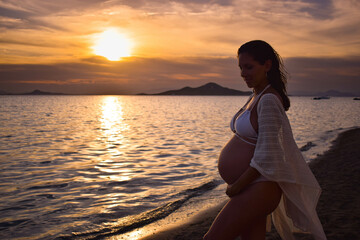 Pregnant woman enjoying a beautiful sunset
