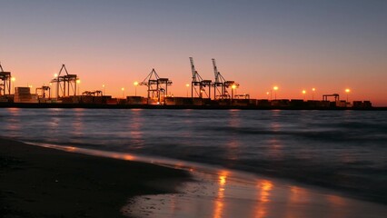 Fototapeta na wymiar Time Lapse Container Ship Terminal and Cranes in the Evening