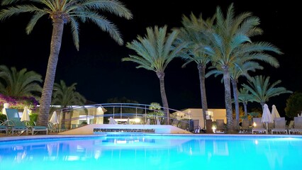 Tropical Resort Swimming Pool and Palm Trees at Night Time Lapse