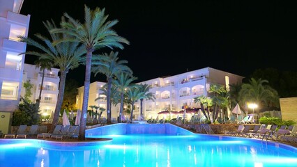 Tropical Resort Swimming Pool and Palm Trees at Night Time Lapse