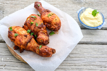 Crispy  deep fried home made    chicken   legs  Breaded  with  almond flour chicken  breast fillets  with chilly peppers and fresh   basil on wooden rustic background. Ketogenic diet food