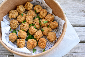 Crispy  deep fried   chicken  nuggets . Breaded  with Cornflakes Breast fillets  with chilly peppers and fresh   basil on wooden rustic background