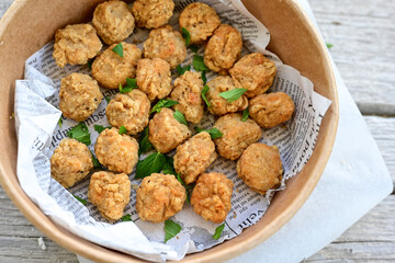 Crispy  deep fried   chicken  nuggets . Breaded  with Cornflakes Breast fillets  with chilly peppers and fresh   basil on wooden rustic background