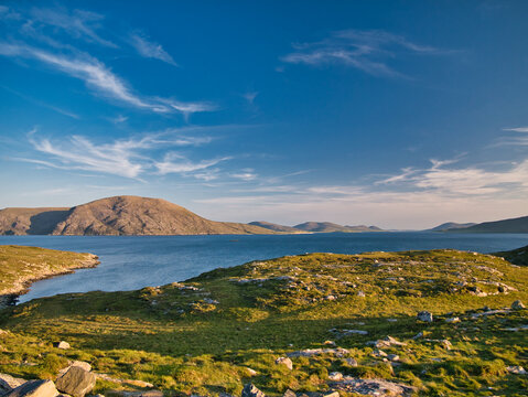 On a calm, summer evening, a view from the B887 road on the south of the island of Harris in the Outer Hebrides, Scotland, UK, looking south toward Luskentyre Bay in the distance.