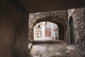 a narrow street with typical architecture in Ponzanello medieval village, Municipality of Fosdinovo, province of Massa-Carrara, Tuscany, Italy - obrazy, fototapety, plakaty