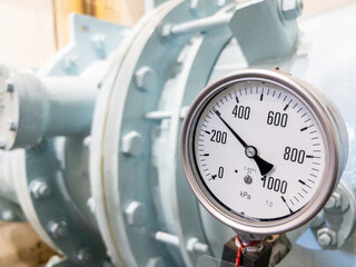Closeup of the large dial gauge on the water pipe.