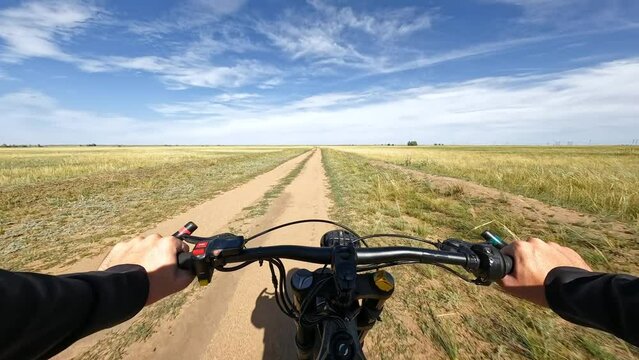 POV Electric Bike Riding through the Cereal Field in Steppe at Partly-Cloudy Day. 60 fps, H.264, 8bit, chroma subsamlping 4:4:4
