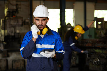 factory workers or engineer talking on walkie talkie in the factory