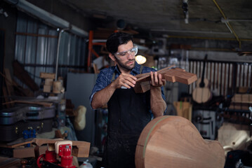 Luthier is working on the neck of a classical guitar