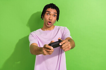 Photo of impressed person pouted lips arms hold controller playing video games isolated on green color background
