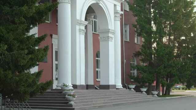 Establishing shot of part of four storey classic style school building facade with columns on summer morningEstablishing shot of part of four storey classic style school building facade with columns o