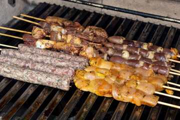grilling meat skewer, traditional brazilian barbecue with meat on skewer known as espetinho or churrasquinho