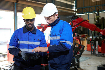 factory workers or engineer using tablet for work in robot factory