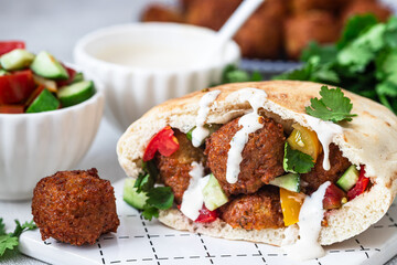 Traditional homemade chickpea Falafel balls with vegetables salad , tahini sauce,chips and pita bread. Vegetarian food concept.	