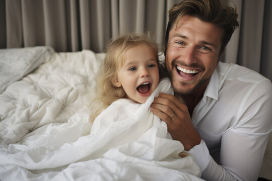 Happy father and daughter laughing together in the morning after waking up