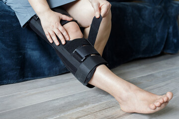 Knee Support Brace on leg. Orthopedic Anatomic Orthosis. Braces for knee fixation, injuries and pain. Orthotics. Foot orthosis tutor - obrazy, fototapety, plakaty