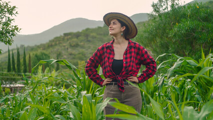Latin Hispanic woman farmer in corn field with position of conviction and trust with epic land...