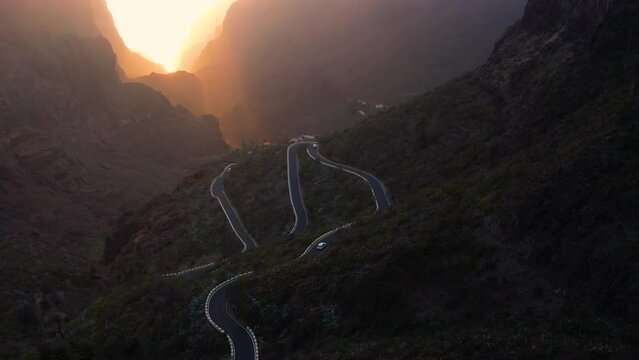 Aerial sunset of Masca valley. Asphalt road and cars on steep volcanic slopes of Tenerife Canary Islands
