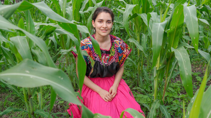 Beautiful smiling Mexican lady with folkloric Mexican clothes sitting on the maize at September 16. Independence Day of Mexico. Mexico concept. Traditional. Cute outfit 