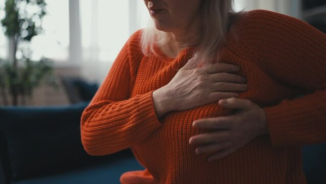 Middle-aged woman having strong breast pain, touching chest, mastitis symptoms