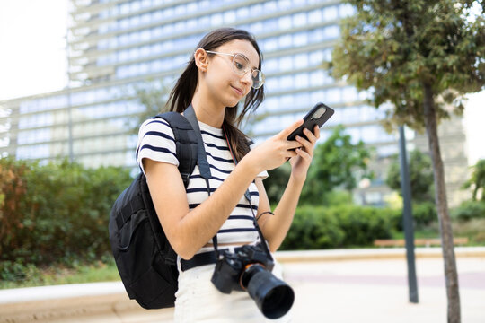 Woman with backpack smartphone and photo camera