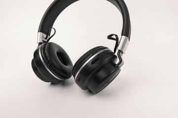 Fototapeta na wymiar Black headphones, wireless headphones on a minimalist white background