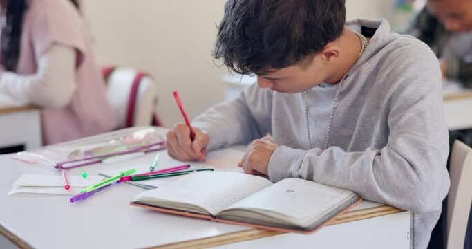 Education, exam and a boy student writing in class during a test or assessment learning or development. School, kids and a male child at a classroom desk for academic study or scholarship assignment