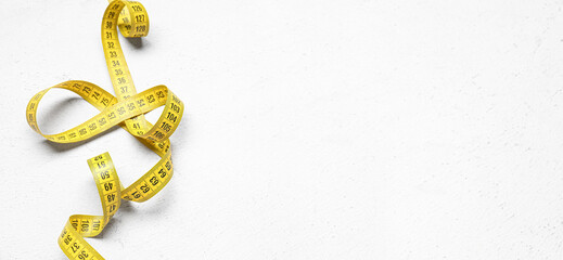 Measuring tape on white background with space for text, top view