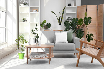 Interior of bright living room with coffee table, cozy sofa and armchair