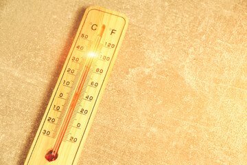 Thermometer showing high temperature.Against background concrete wall.