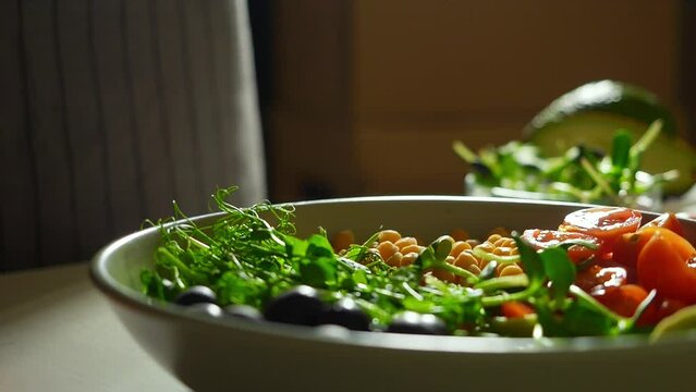 super slow motion video of microgreens falling on a plate full of colorful vegetables. healthy eating ingredients, cooking healthy bowl recipes 1000 fps, 