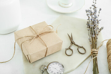 Tied box with scissors and dried lavender on white table
