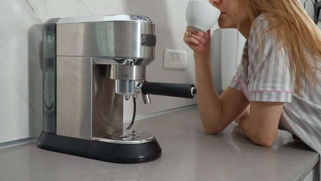 carob coffee maker silver. Metallic coffee machine pours black coffee, cappuccino, latte, espresso and flat white into a small white cup