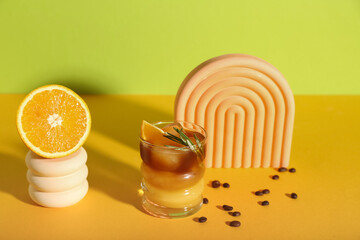 Glass of tasty orange espresso on color background