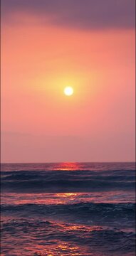 Sun is rising up over sea horizon, beautiful tropical sunrise 4K vertical video