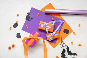 Halloween decorations with gift boxes, candy corns and wrapping paper on white background