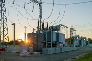 High voltage transformer and rays of the morning sun. Illumination from sunrise.