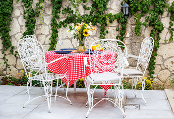 Table set for an event party or wedding reception in a summer garden Italian or Spanish style 