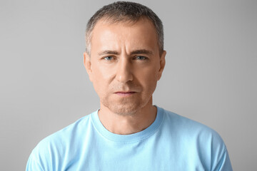 Portrait of serious mature man on grey background