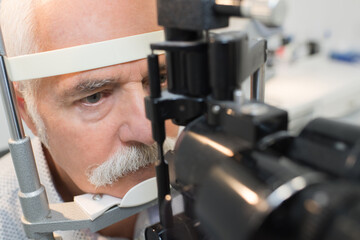 close-up of senior man having eyesight test in clinic