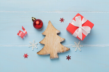 Miniature christmas tree with gift box and decor on wooden background