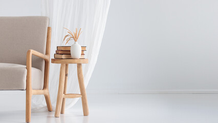 Wooden handcraft chair with books and vase on white background