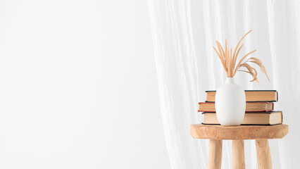 Wooden handcraft chair with books and vase on white background