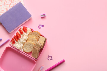 Lunchbox with delicious food and different stationery on pink background