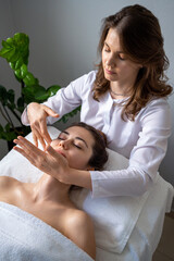 Obraz na płótnie Canvas Beautician woman making lymphatic drainage face massage or facelifting massage at the beauty salon. Face Treatment. Beauty injection procedure for skincare.