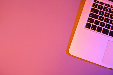 Modern laptop on pink background